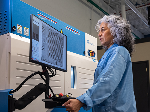 DIVSYS provides x-ray analysis for Indianapolis PCB Manufacturing image shows female technician studying screen