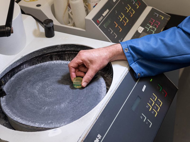 DIVSYS can offer many lab capabilities with its Indianapolis PCB Manufacturing image shows technician working on microsection